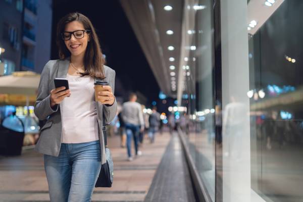 Fille marchant dans la rues avec un téléphone portable