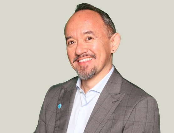 CIS expert Hugo Gordillo, een professional in zakelijke kleding, die vriendelijk glimlacht tegen een neutrale achtergrond.