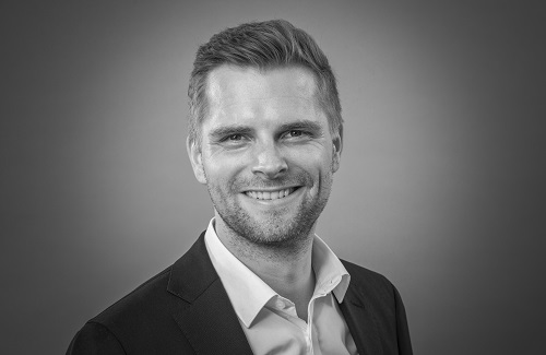 Zwart-wit portretfoto van Dr. Simon Monske.
