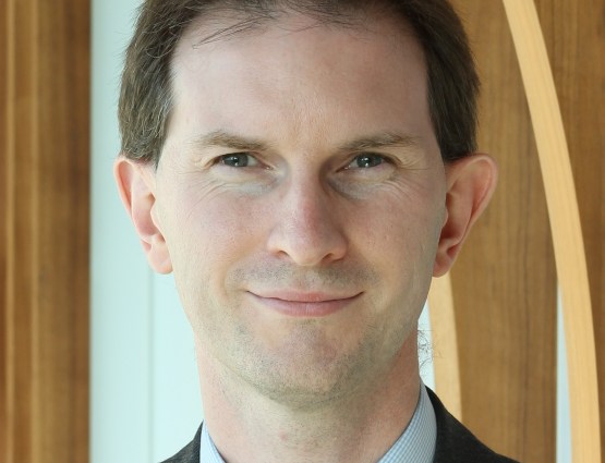 Een professionele portretfoto van James Robey, een medewerker van Capgemini, gekleed in een formeel pak.