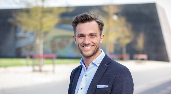 Julian van Velzen die glimlachend in de camera kijkt.
