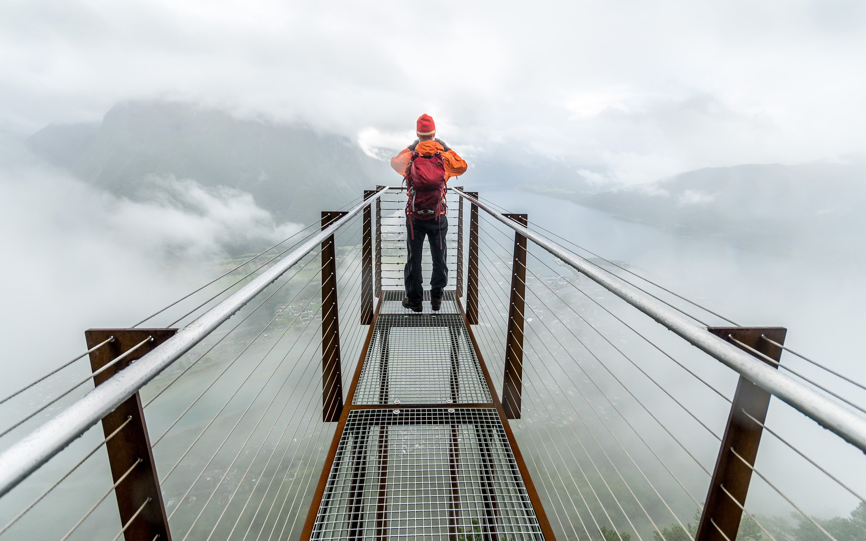 Een man die aan de top van de Romsdalstrappa staat en uitkijkt over de bergen in Åndalsnes, Noorwegen.