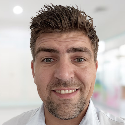 Een professionele portretfoto van Quido, die glimlachend naar de camera kijkt.