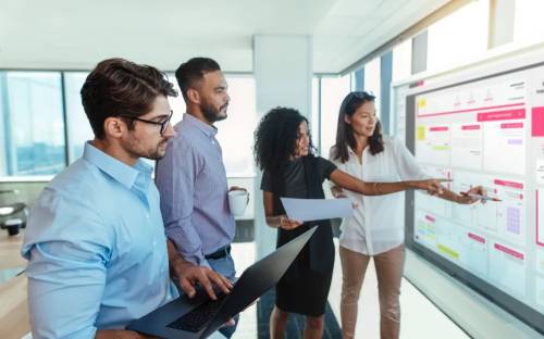 a group of young people in the office discussing about charts and company efforts