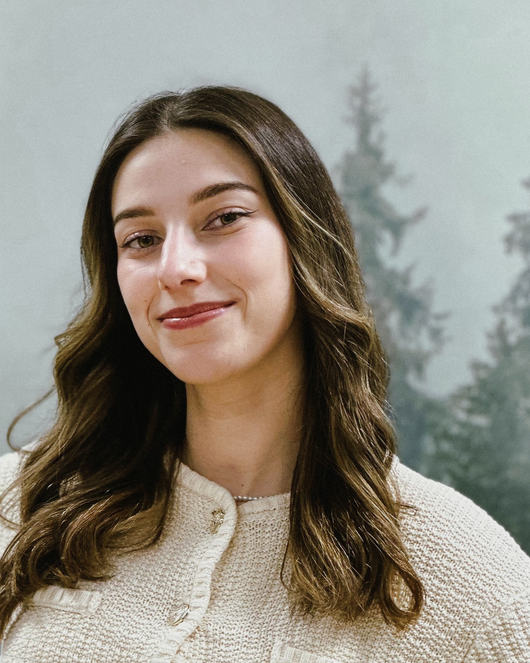 Julia Dundar - młoda kobieta, w ciemnych blond włosach i białej bluzce,UX/UI Designerka.