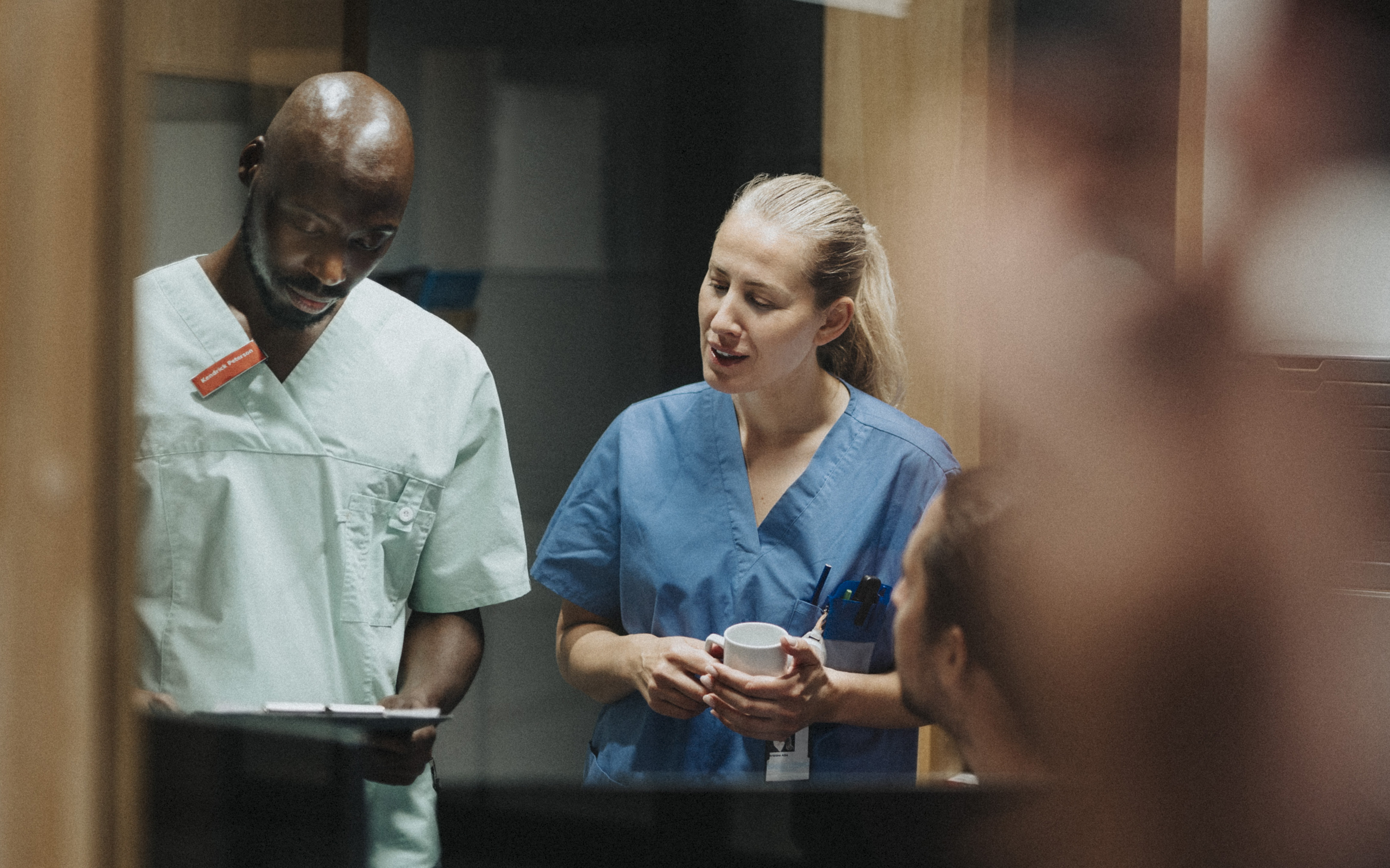 A nurse and a doctor engaged in a conversation in a medical setting, discussing patient care